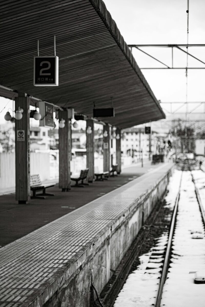 Black and white photo of an empty railway platform covered in snow at Fuji, Shizuoka.